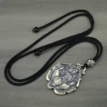 Amulette argentée, symbole de protection bouddhiste